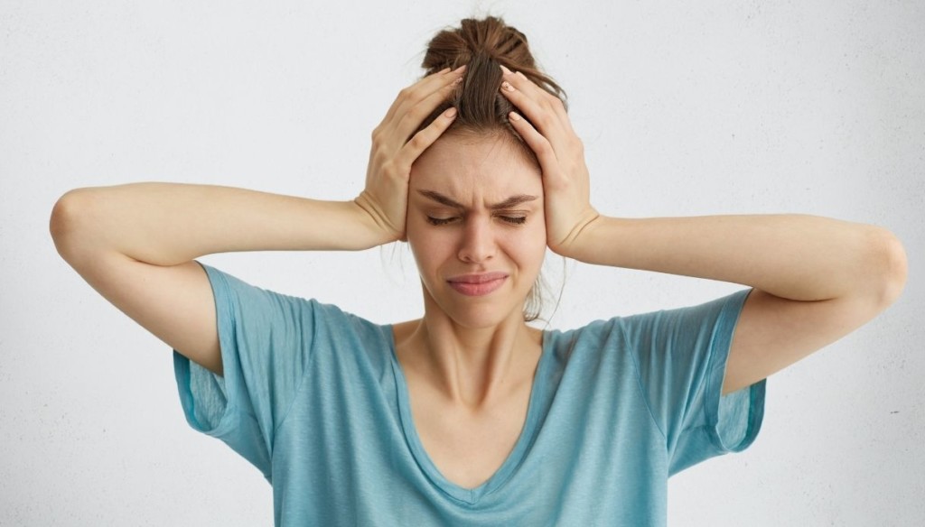 donna con mal di testa e indicazioni per l'utilizzo dei cerotti plantari detox